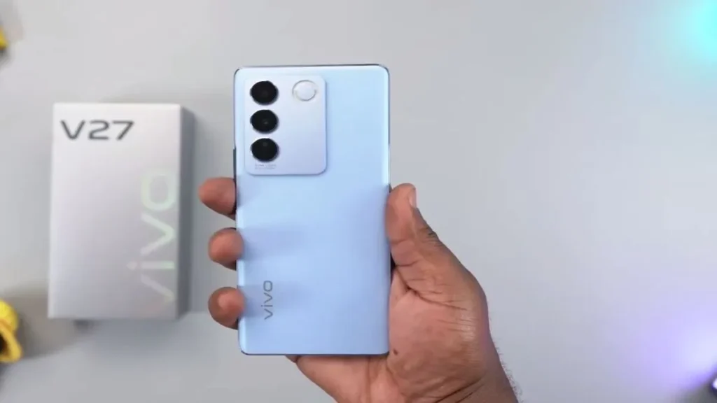 Vivo V27 5G in hand showing triple rear camera setup and sleek blue design