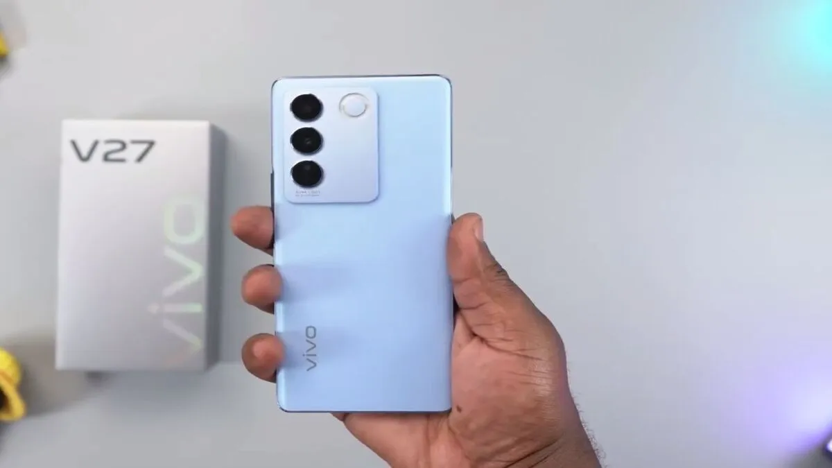Vivo V27 5G in hand showing triple rear camera setup and sleek blue design